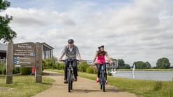 two cyclists riding by the lake in Nene Park