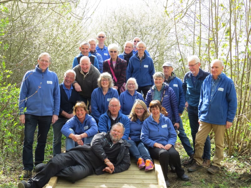 Group of volunteers being photographed on the boardwalks in bluebell woods