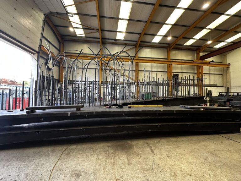 a large workshop with a deconstructed metal bridge inside