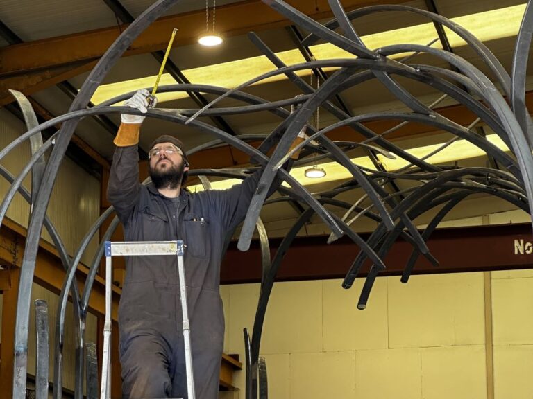 welder in a workshop constructing a new metal bridge