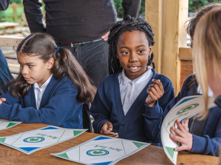 two school girls with their worksheets on an outdoor school visit