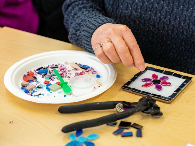 woman making a glass mosaic coaster at a craft workshop
