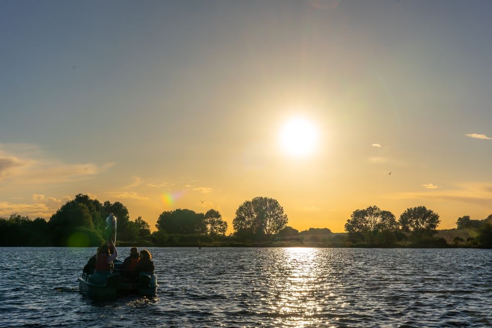evening sunset view across gunwade lake with a dragon pedalo on the water