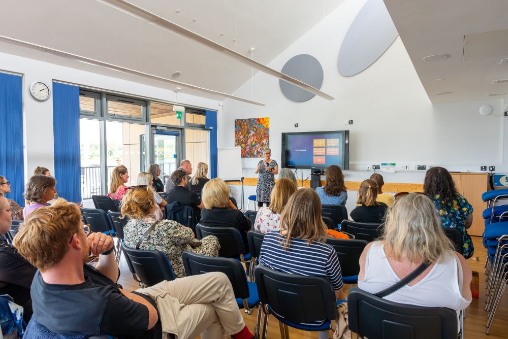 lakeside meeting room with a presentation and audience of guests