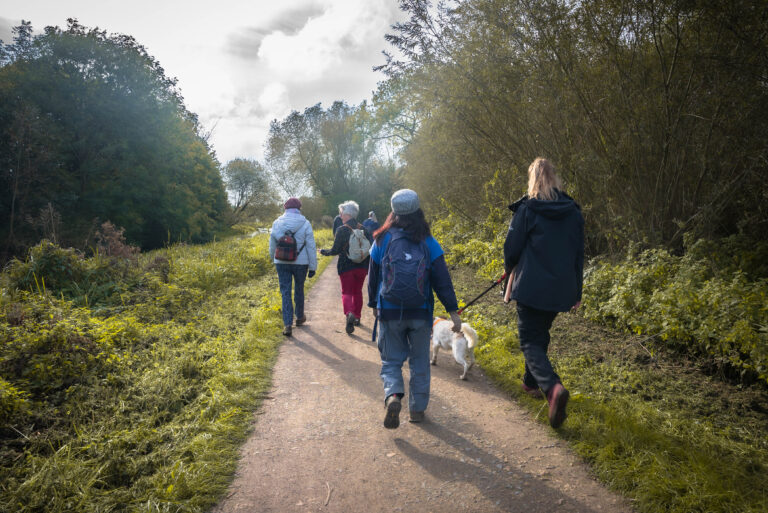 Group of people walking along a path in the countryside.