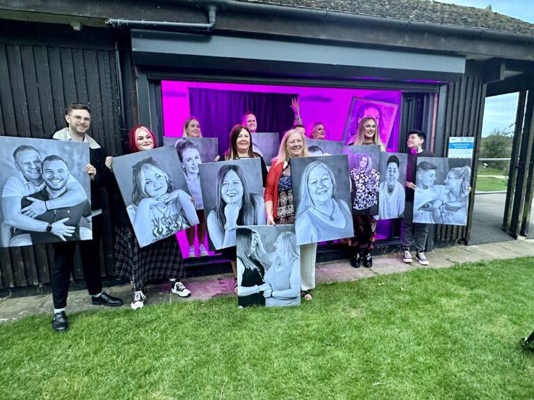Group of people holding up photos