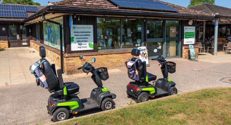 Two mobility scooters outside of the visitor centre in Ferry Meadows