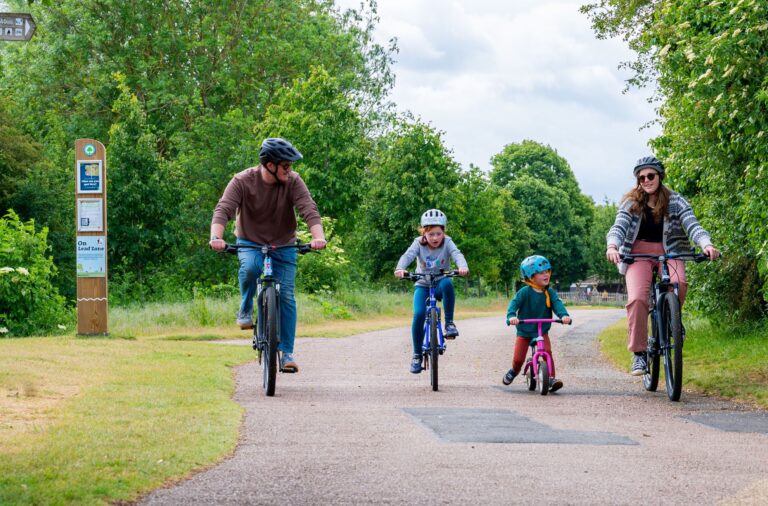 Family of four enjoying a bike ride in a country park