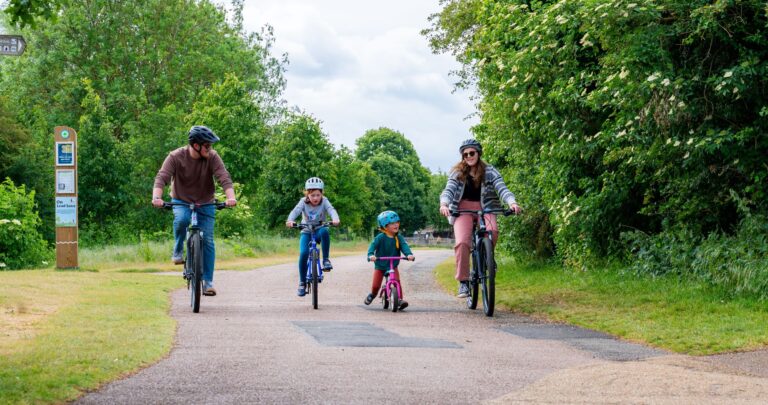 Family of four enjoying a bike ride in a country park