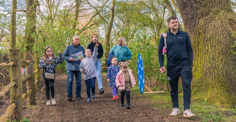 A family walking through a woodland following an easter trail