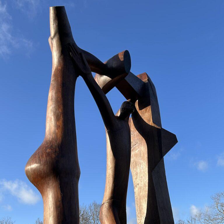 Wooden sculpture depicting a figure standing in an archway.