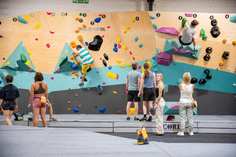 People climbing on colourful bouldering walls in a climbing centre