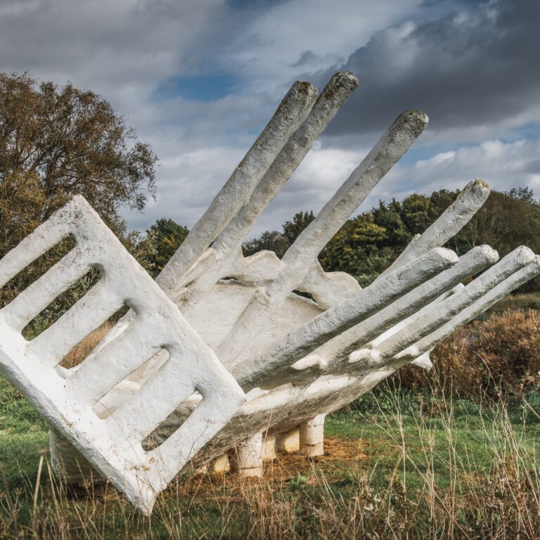 White sculpture set in landscape.
