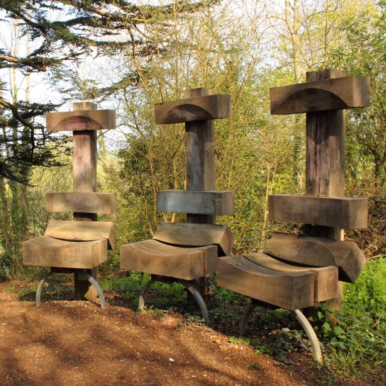 wooden seat sculptures set in woodland