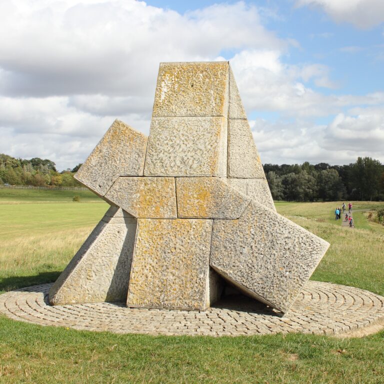 stone sculpture that looks like a pyramid in a landscape setting.