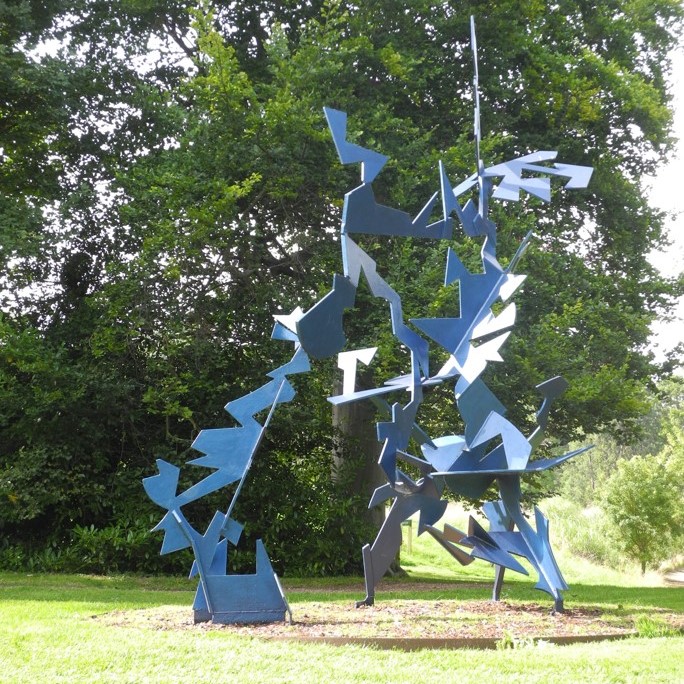 Metal sculpture in landscape setting.