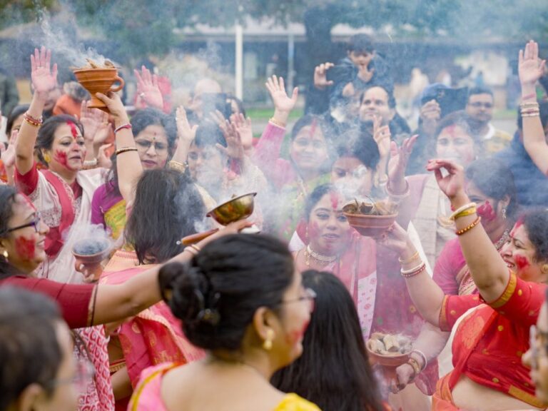 Group of women in traditional Indian dress taking part in the Hindu celebration of Durga Puja.