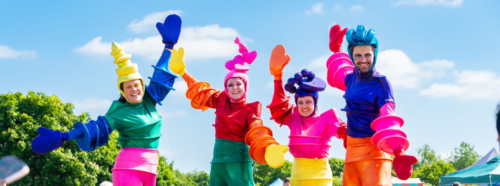 group of four stilt walkers wearing colourful costumes