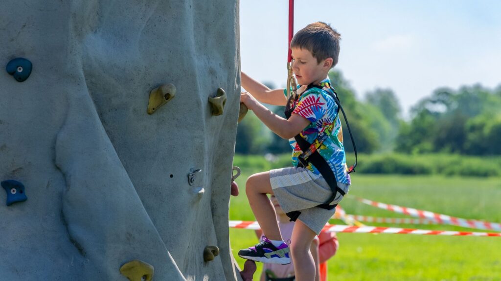 Boy enjoying a climbing wall outside