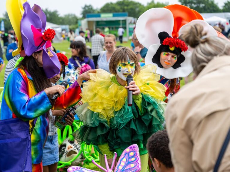 Group of people in colourful fancy dress in an outdoor festival.