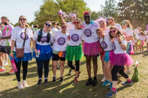 a group of runners taking part in a charity race covered in coloured paint