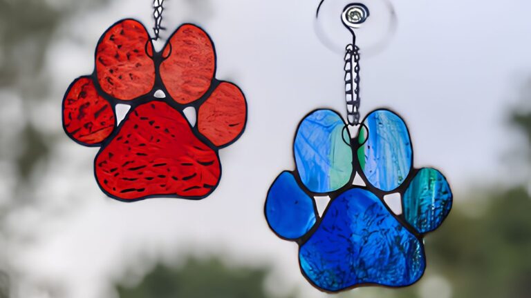 Blue and red paw print suncatchers hanging in a window