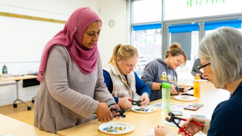 Women taking part in an indoor mosaic workshop