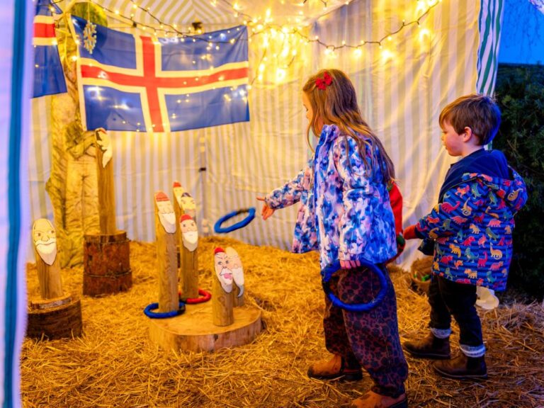 two young children playing a carnival game at a christmas event